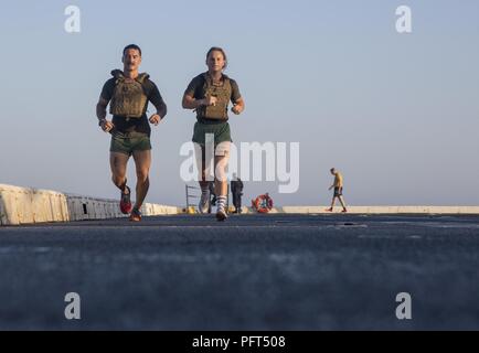 MEDITERRANEAN SEA (May 28, 2018) U.S. Marine Corps Staff Sgt. Leo Ostrolenckk, left, from Kansas City, Missouri, and Cpl. Gabrielle Green, from Perkasie, Pennsylvania, both assigned to Battalion Landing Team, 26th Marine Expeditionary Unit, participate in the Memorial Day “Murphy” workout, a workout used by Medal of Honor recipient Lt. Michale Murphy, aboard the San Antonio-class amphibious transport dock ship USS New York (LPD 21) May 28, 2018. New York, homeported in Mayport, Florida, is conducting naval operations in the U.S. 6th Fleet area of operations in support of U.S. national security Stock Photo