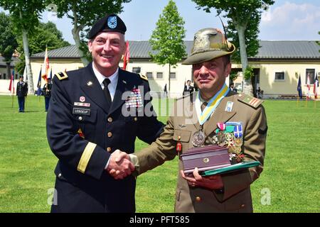 The outgoing Italian Base Command Sgt. Maj. Antonio Quaglia (right), receives a gift from Brig. Gen. Eugene J. LeBoeuf, acting Commander of U.S. Army Africa (left), during the Italian Base Command Change of Responsibility at Caserma Ederle in Vicenza, Italy, May 31, 2018.