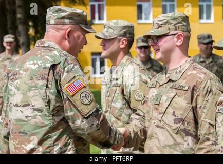 Yavoriv, Ukraine – Maj. Gen. Raymond Shields, commander of the New York Army National Guard, presents a challenge coin to Pfc. Christopher Finn at the Yavoriv Combat Training Center May 25. Finn, a Liverpool, N.Y., native, serves as a wheeled vehicle mechanic assigned to the Joint Multinational Training Group – Ukraine, and was presented a coin in recognition of his hard work during the deployment. Stock Photo