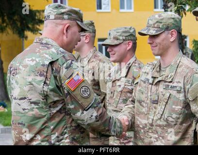 Yavoriv, Ukraine – Maj. Gen. Raymond Shields, commander of the New York Army National Guard, presents a challenge coin to Sgt. 2nd Lt. Clayton Cerne at the Yavoriv Combat Training Center May 25. Cerne, a North Collins, N.Y., native, serves as the Joint Multinational Training Group – Ukraine communications officer and was presented a coin in recognition of his hard work during the deployment. Stock Photo