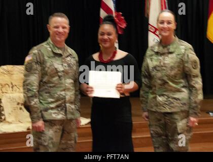 Col. Christopher Lindner, acting commander, William Beaumont Army Medical Center, and Command Sgt. Maj. Janell Ray, command sergeant major, WBAMC, present a member of Tama’ita’i Toa O Samoa, who performed traditional Polynesian dances during the Fort Bliss Asian American Pacific Islander Heritage Month observance, a token of appreciation during the observance at the Centennial Banquet and Conference Center, Fort Bliss, May 23. Stock Photo