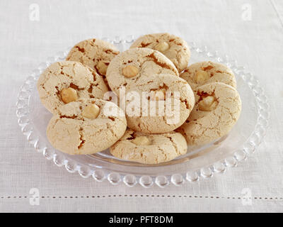 Coffee and hazelnut macaroons on glass cake stand Stock Photo