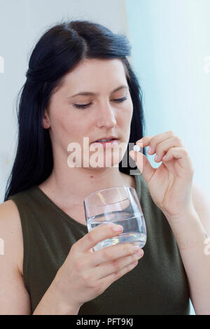 Woman taking medication Stock Photo
