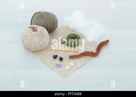 Wool, crochet hook, stuffing and accessories needed to make a toy bear Stock Photo