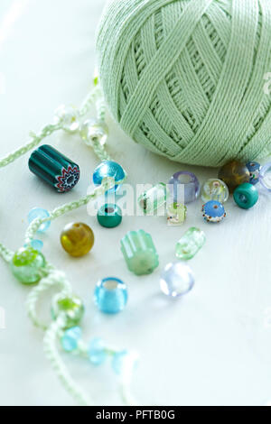 Green yarn and glass beads to make a necklace Stock Photo
