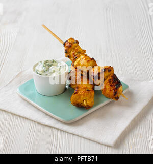 Chicken tikka skewers with cucumber and mint raita Stock Photo