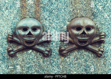 Details on an old gravestone. To smiley skulls with bones. Stock Photo