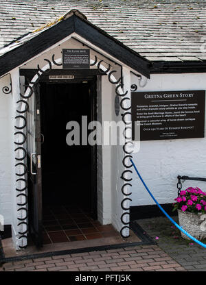 Gretna Green, United Kingdom - August 08 2018:   A doorway decorated with horseshoes for good luck, used by couples getting married at Gretna Green's  Stock Photo