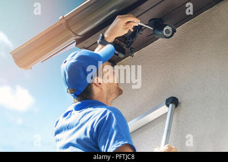 man install outdoor surveillance ip camera for home security Stock Photo