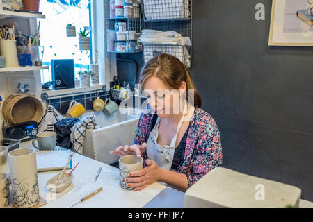 A young lady working in her workshop making ceramic jugs Stock Photo