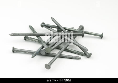 A small pile of silver, galvanized, zinc plated sixteen penny nails used by contruction workers for framing when building homes and houses. Stock Photo