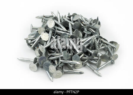 A pile of shiny, silver, galvanized, zinc plated roofing nails that construction workers use to attach shingles to the roofs of houses and homes when  Stock Photo