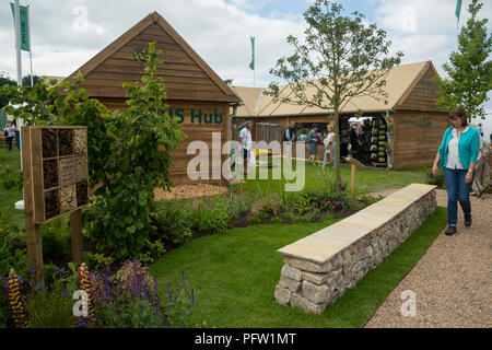 People shopping at country show visit & look round RHS Hub trade stand & view small display garden - Chatsworth Flower Show, Derbyshire, England, UK. Stock Photo