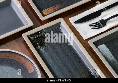 Square dishes of dark color on the table Stock Photo