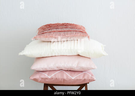 Pink and white pillows on the wall background. Close up Stock Photo