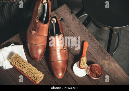 Monk shoes arranged on a wooden table with accessories for cleaning shoes Stock Photo
