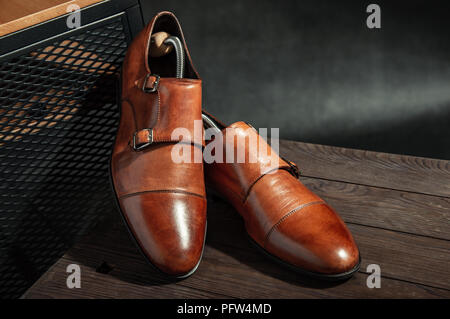 Elegant brown monk shoes with double strap on a wooden table Stock Photo