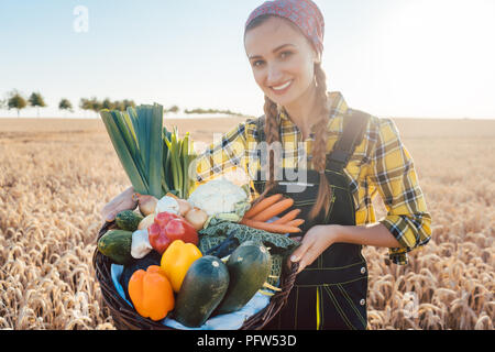 Harvest time in the country, woman farmer offering vegetables Stock Photo