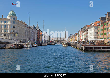 View through Nyhavn canal with vintage ships and colourful houses towards Kongens Nytorv in Copenhagen. Crowded bars and restaurants and vintage ships Stock Photo