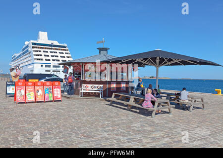 Ice and refreshment stall on the Langelinie pier in the harbour of Copenhagen in late summer. Cruise ship NAUTICA moored at the Langelinie quay. Stock Photo