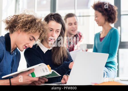 Two young students searching for an answer to their question Stock Photo