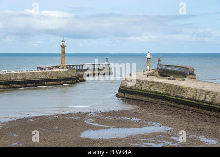 Piers and lighthouses at the entrance to Whitby harbour on the coast of North Yorkshire, England. Stock Photo