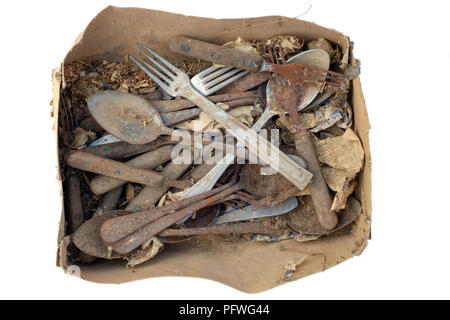 cardboard box full of old rusty cutlery cut out and isolated on a white background Stock Photo