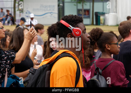 A young black man wearing Beats headphones in a crowd Stock Photo