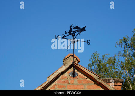 weather vane designed as a witch with black cat on a broomstick mounted on a gable end of building zala county hungary Stock Photo