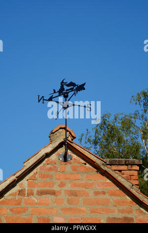 weather vane designed as a witch with black cat on a broomstick mounted on a gable end of building zala county hungary Stock Photo