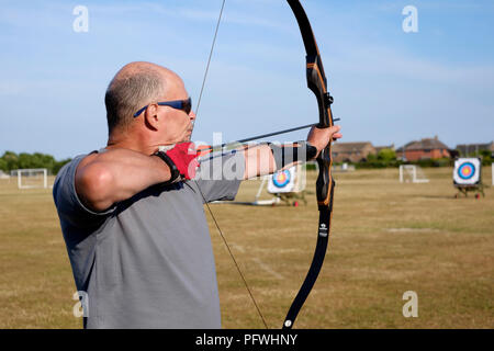 male archer using a bow for target practice at an archery club Stock Photo