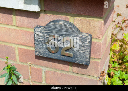 House number 52 sign on red brick wall Stock Photo