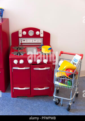 Cooktop stove, oven, refrigerator and shopping cart toys for children. Stock Photo