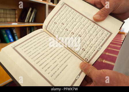 Canberra, ACT, Australia - October 2006: Man reads from Chinese language Quran in Canberra mosque Stock Photo