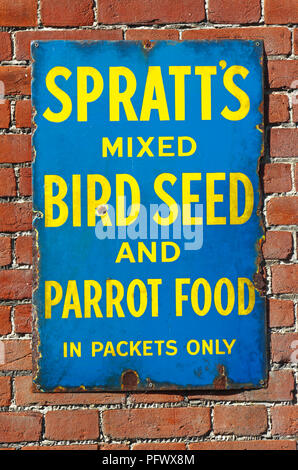 An old enamel sign advertising Spratt's Bird Seed and Parrot Food at the railway station at Acle, Norfolk, England, United Kingdom, Europe. Stock Photo