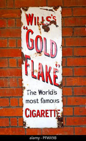 An old enamel sign advertising Will's Gold Flake Cigarettes at the railway station at Acle, Norfolk, England, United Kingdom, Europe. Stock Photo