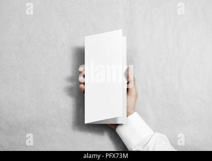 Hand holding blank white flyer brochure booklet in the hand. Leaflet presentation. Pamphlet hold hand. Man show fold offset paper. Sheet template. Boo Stock Photo
