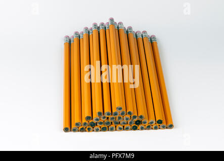 A stack or orange, unsharpened, six-sided pencils neatly stacked in a pyramid with the pink erasers facing away as they are waiting to be sharpened fo Stock Photo