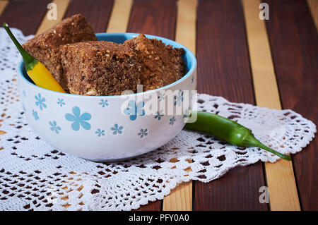 Whole grain spelta bread in bowl on dinner table Stock Photo