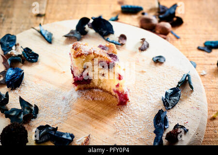 Cake with cherries on wooden table with sugar on top Stock Photo