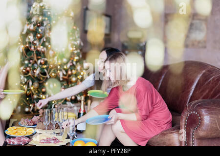 Happy women having some snacks with champagne while celebrating Christmas Stock Photo