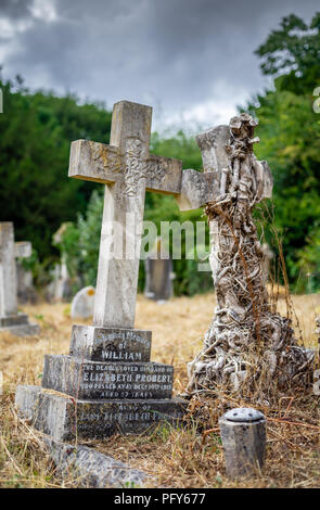 Cemetery scene with a crooked old 19th century headstone cross at the Southampton Old Cemetery, Southampton, Hampshire, England, UK Stock Photo