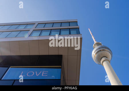 Berlin TV tower (Fernsehturm) abstract next to a modern building with the word 'Love' displayed, Berlin Mitte, Germany Stock Photo