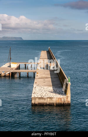 Burnie, Tasmania, Australia - December 15, 2009: Lateral closeup of brown-beige defensive sea wall surrounded by blue water in front of port. Plenty o Stock Photo