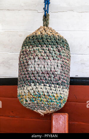 Darwin, Northen Territory, Australia - December 1, 2009: Closeup of woven mulitcolor big bumper ball on line used to protect side of boat when docking Stock Photo