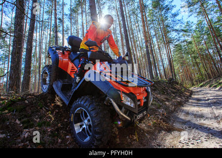 Man rises a quad bike in the forest. Stock Photo