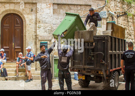 10 May 2018 Men loading a small utility vehicle with waste on the narrow Via Dolorosa Jerusalem Israel Stock Photo