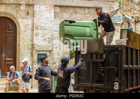 10 May 2018 Men loading a small utility vehicle with waste on the narrow Via Dolorosa Jerusalem Israel Stock Photo