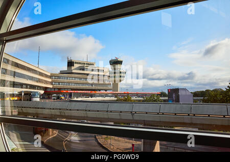 Berlin, Germany - August 15, 2018: Tegel Airport main building and traffic control tower seen through a window in the morning. Stock Photo