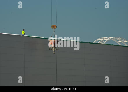 NOVI SAD, SERBIA - July 14th: Worker supervising crane lifting weight Stock Photo